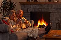 Picture of an older couple sitting in front of a fireplace